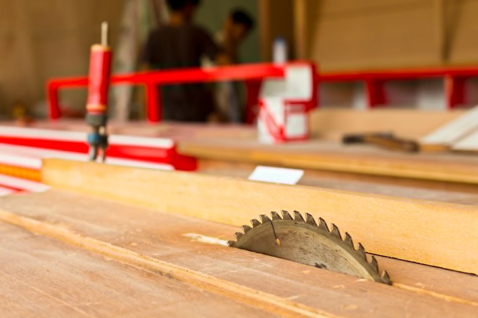 Wide view of the workshop with a table saw in use and lumber staged nearby