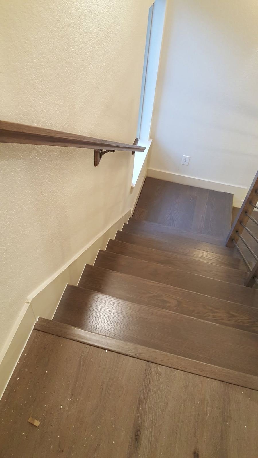 Interior staircase with a custom wood handrail mounted along the wall